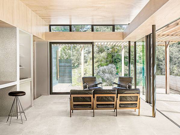 Open plan living space with child on kitchen stool, toddler running towards camera and mother sitting in chair. PEKA PEKA II HOUSE, Peka Peka - Kapiti Coast, New Zealand. Architect: HMA, 2016.